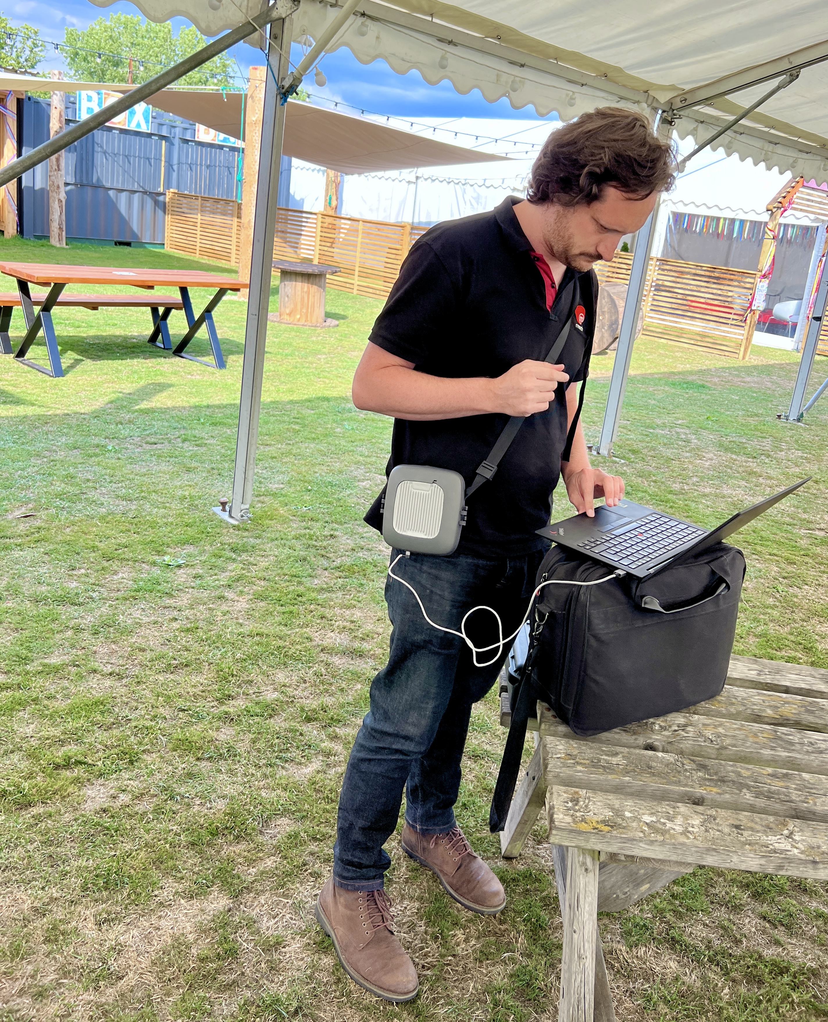 On-site M-Tech engineer monitoring the festival network from a laptop on the bar