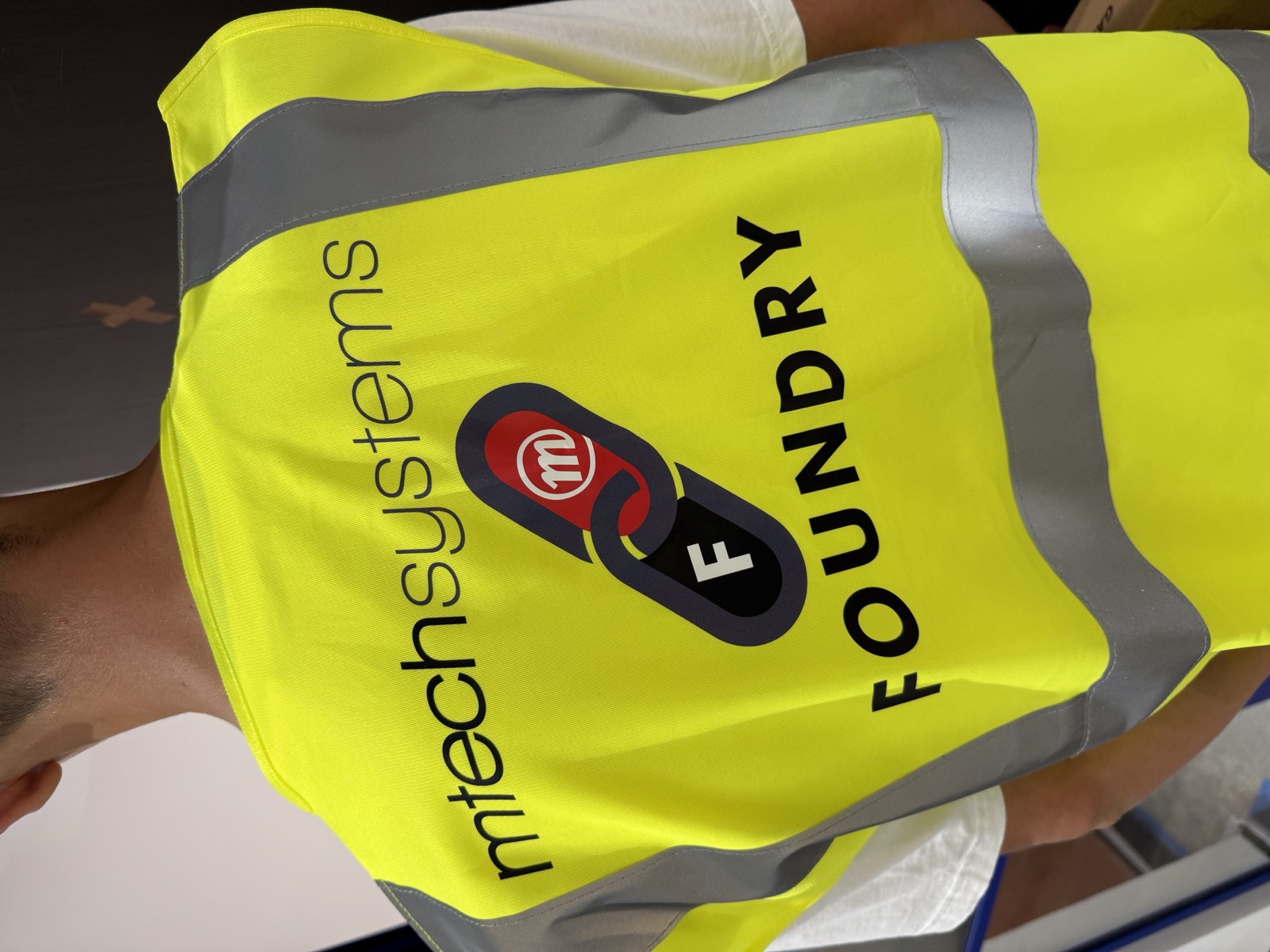 Co-branded mtechsystems × FOUNDRY hi-vis vest worn on site