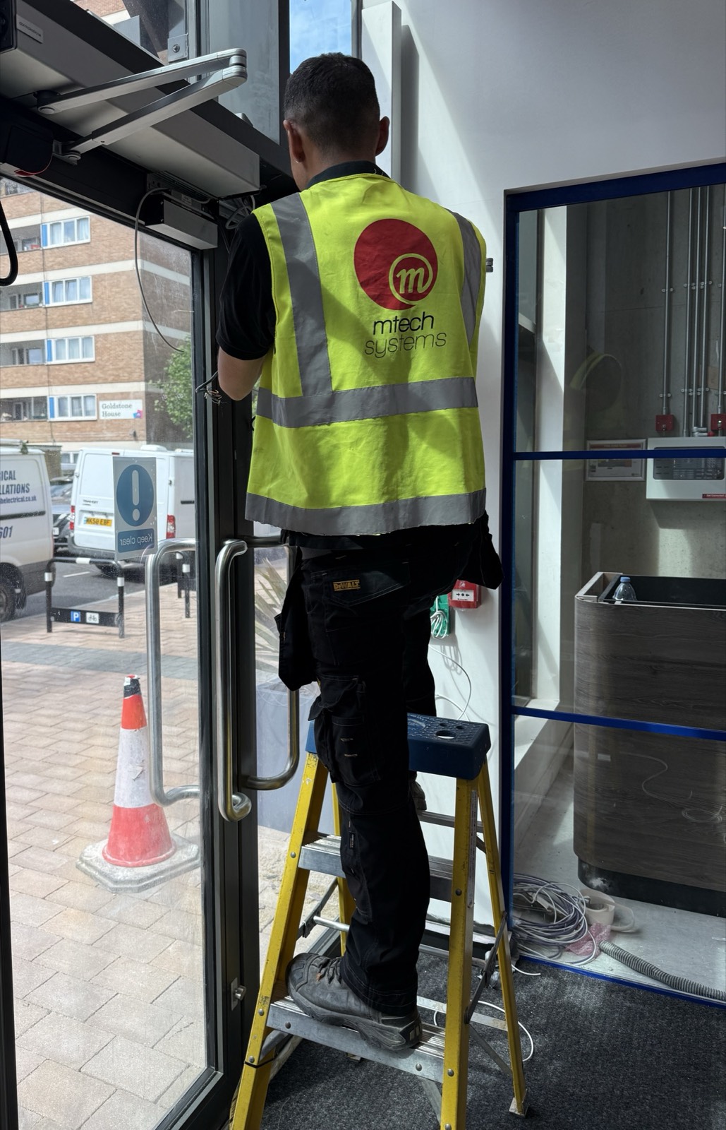 M-Tech Systems engineer installing kit at a FOUNDRY entrance