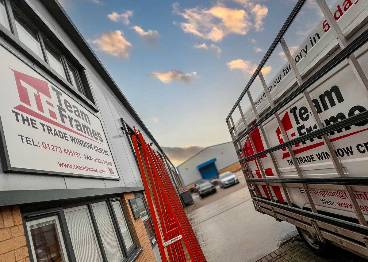 Team Frames trade window centre signage at the Brighton trade counter, with one of the Team Frames delivery vehicles parked outside