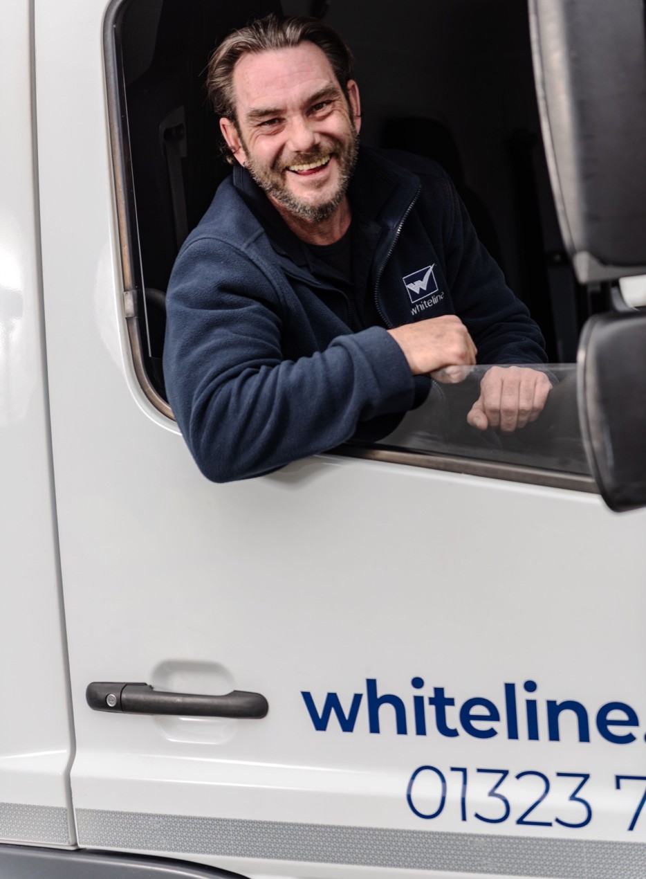 Whiteline Group team member leaning out of a branded Whiteline van